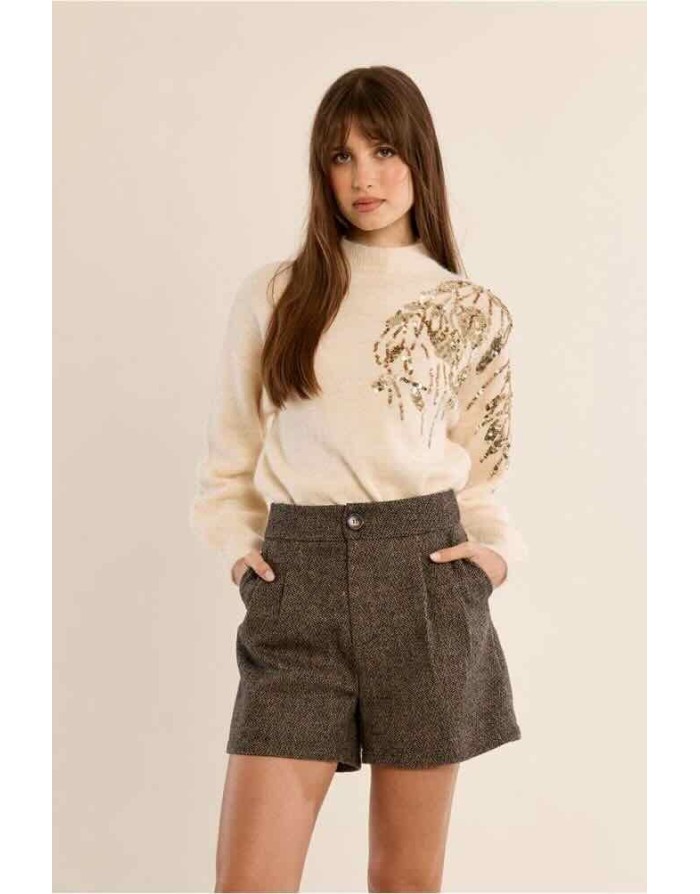 Un short taille haute en lainage chiné brun et beige mêlés, à la coupe évasée et aux plis couture — la pièce audacieuse et sophistiquée qui réinvente le vestiaire automne-hiver avec une élégance british décomplexée. Référence : P1846EH